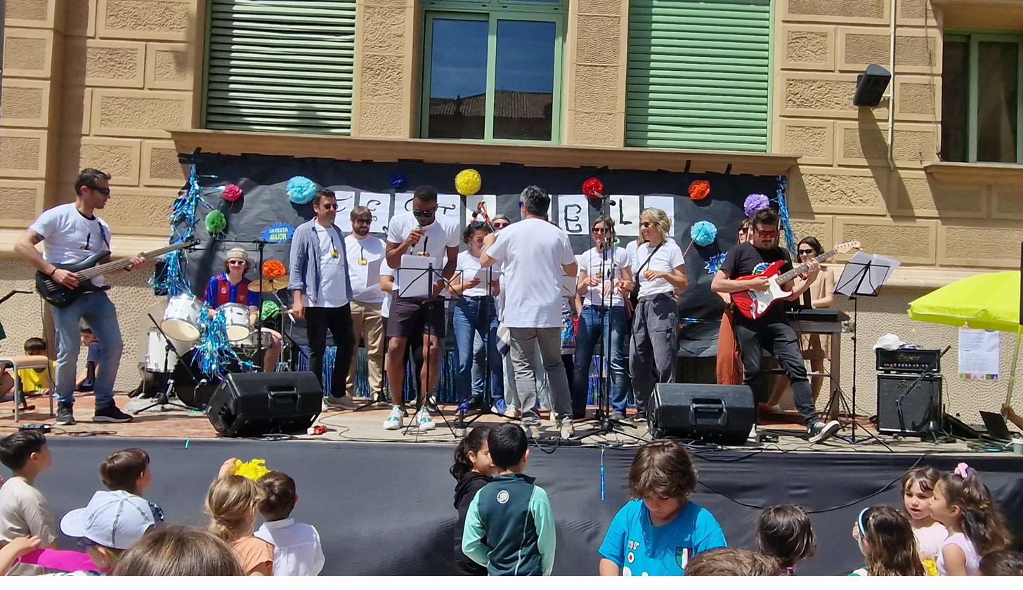 La banda tocant en una festa de l'escola amb els nens asseguts al davant